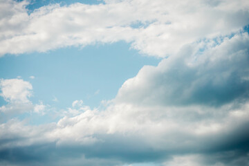 Naklejka na ściany i meble Blue sky with floating white clouds. The background.