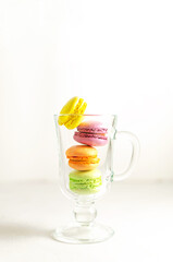 Delicious sweet cookies, colored cakes with macaroons in a transparent glass cup. White background. summer cocktail concept. close-up with place for text