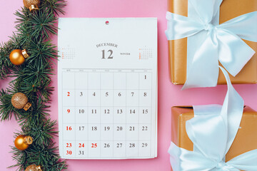 Calendar page of december with festive decorations on pink background