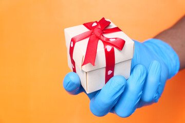 male hand in a blue medical glove gives a gift.