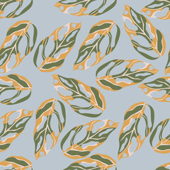 Seamless random monstera silhouettes seamless exotic pattern. Tropical leaves in beige and green tones on light blue background.