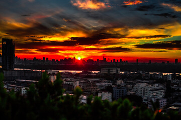 Fototapeta premium The high angle background of the city view with the secret light of the evening, blurring of night lights, showing the distribution of condominiums, dense homes in the capital community