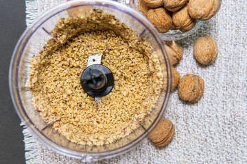 roasted peanuts in glossy plastic blender with gray metallic knife. Cooking of home made from...