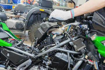 The master performs maintenance on the motorcycle.
