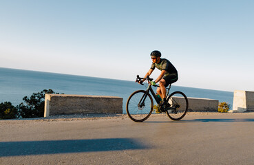 Obraz premium Cycling sport athlete man riding on coastal road
