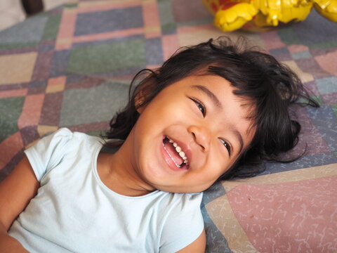 A portrait of adorable Asian kid girl laughing  