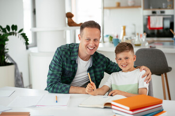 Father helping her son with homework at home. Little boy learning at home..