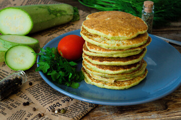 vegetarian zucchini pancakes on a wooden background with natural yogurt, garlic and herbs. Vegetarian, healthy food.