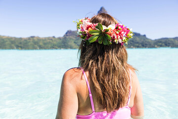 Beautiful woman wearing colorful flower crown while on a tropical island vacation in Bora Bora near...