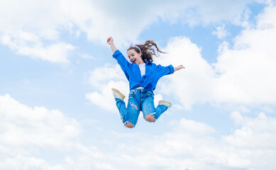 Fototapeta na wymiar free your imagination. kid beauty and fashion. child jump in casual style. Child jumping on background of sky. summer holiday concept. childhood happiness. happy childrens day. Beautiful female