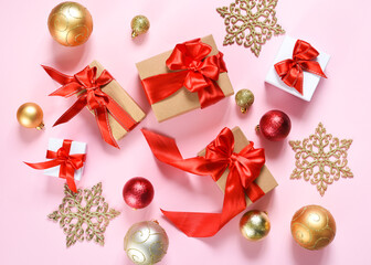 Beautiful composition. Christmas pink background with fir, christmas gifts and decor. Top view with space for copy.
