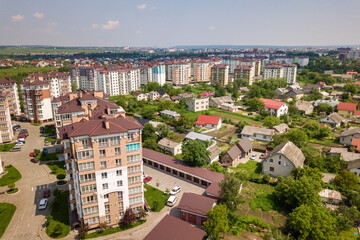 Fototapeta premium Top view of apartment or office tall buildings, parked cars, urban city landscape. Drone aerial photography.
