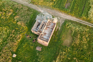 Aerial view of building site for future house, brick basement floor and stacks of brick for construction.