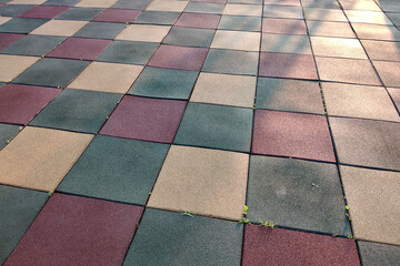 Close up of soft rubber tiles for covering at outdoor gym of stadium at preschool yard.