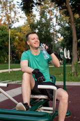 Refreshment during a training in outdoor gym on exercise equipment