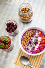 Dragon fruit smoothie bowl with berries and toppings, healthy breakfast cereal