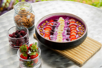 Fototapeta na wymiar Tasty dragon fruit smoothie bowl with berries and toppings, healthy breakfast cereal