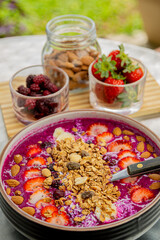 Tasty dragon fruit smoothie bowl with berries and toppings, healthy breakfast cereal
