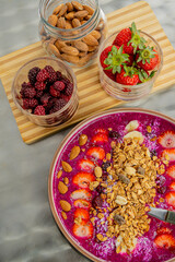 Tasty dragon fruit smoothie bowl with berries and toppings