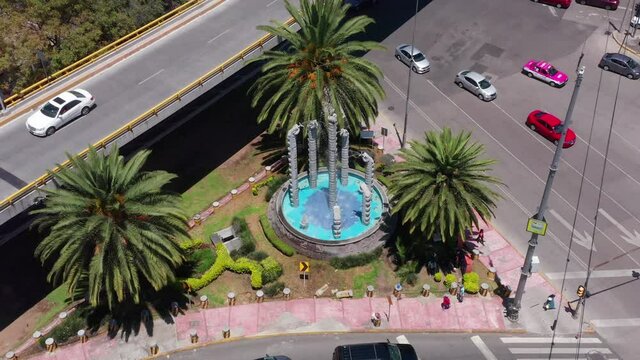 Snake like fountain in Mixcoac neighborhood in Mexico City between a busy street interjection