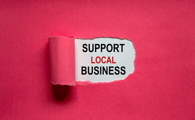 The text 'support local business' appearing behind torn pink paper. Business concept, copy space.