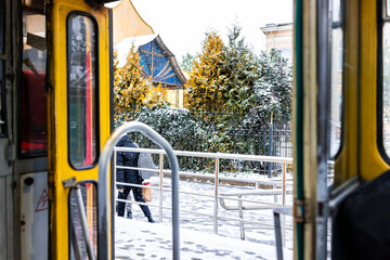 Lviv, Ukraine trolley bus train tram in Lvov with local people walking outside in historic Ukrainian city in winter with snow weather and open doors