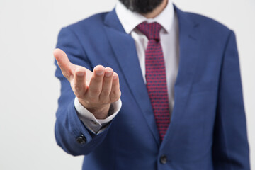person in blue suit, red tie and white shirt, showing his hand