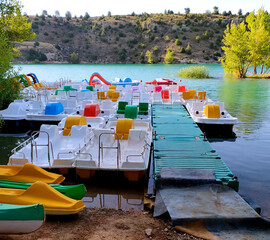 Small jetty at the foot of a lake with beautiful colored boats in the arquillo reservoir in san...