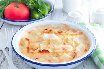 boulanger potato casserole in a round enamel tin, horizontal