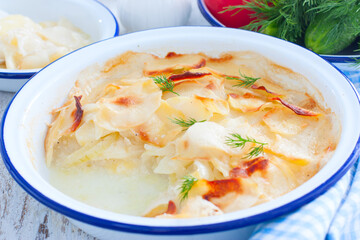 boulanger potato casserole in a round enamel tin, horizontal