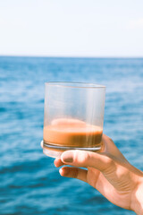 Glass of coffee with the sea on the background