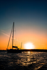 Sailboat silhouette anchored at the island of Ibiza during sunset
