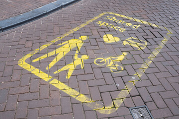 Yellow signs on the street indicate a Shared Space area in Amsterdam, a concept where priority and...
