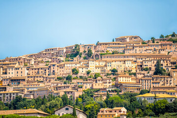 Fototapeta na wymiar Town village city of Assisi in Umbria, Italy cityscape of buildings during summer day landscape with hilltop houses and blue sky