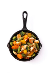 Stir fry chicken with vegetables on iron pan isolated on white background. Top view
