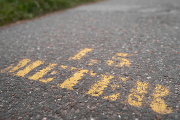 Social distance text 1.5 METER with yellow paint applied to the asphalt of a sidewalk in the Netherlands. Coronavirus measures and Dutch government rules for social distancing