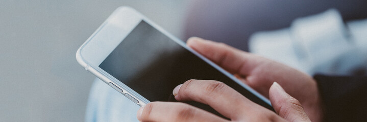 Female holding a white smartphone 