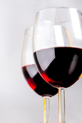 Red wine in glasses on a light gray background close-up.