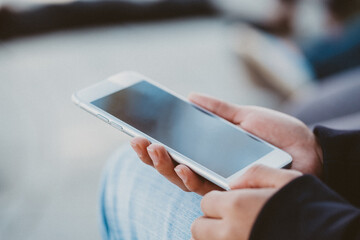 Female holding a white smartphone 