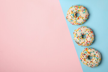 Tasty donuts on two tone background, top view