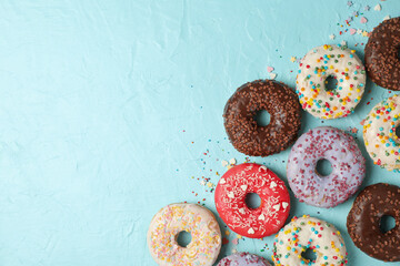 Tasty donuts on blue background, top view