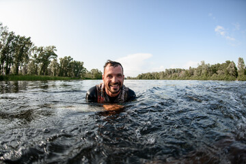portrait of cheerful man in the river water.