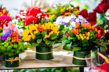 Closeup of florist flower shop display with many bouquets plants floral arrangements in Campo de fiori in Rome, Italy with sunflowers and peppers
