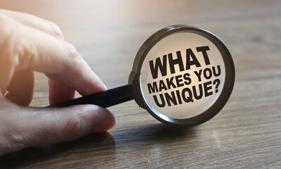 What makes you unique question under magnifying glass. Career business concept