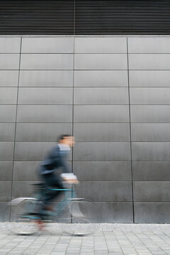 Unsharp, blurry image of a business man on his bike