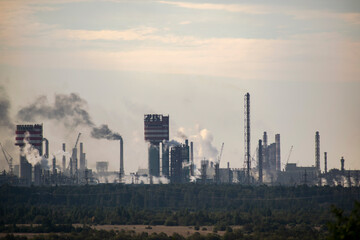 Fototapeta na wymiar Industrial plant in the haze of smog exhaled pipes.