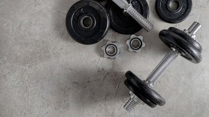 Obraz na płótnie Canvas Steel dumbbells on the cement floor in the gym For bodybuilders