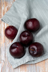 Purple plums on a linen cloth, close up, selective focus