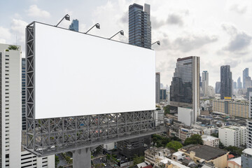 Obraz premium Blank white road billboard with Bangkok cityscape background at day time. Street advertising poster, mock up, 3D rendering. Side view. The concept of marketing communication to promote or sell idea.