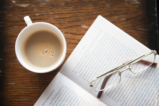 reading a book and heaving a cup of coffee